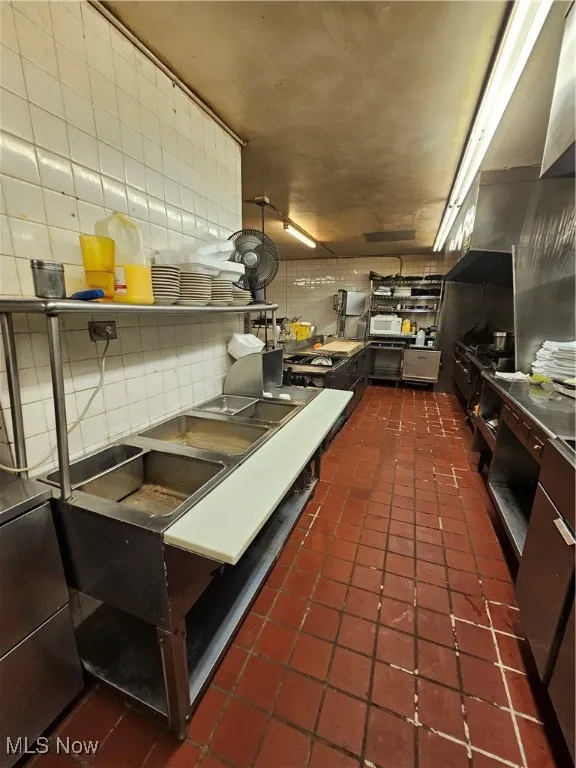 Kitchen featuring tasteful backsplash and dark tile patterned flooring