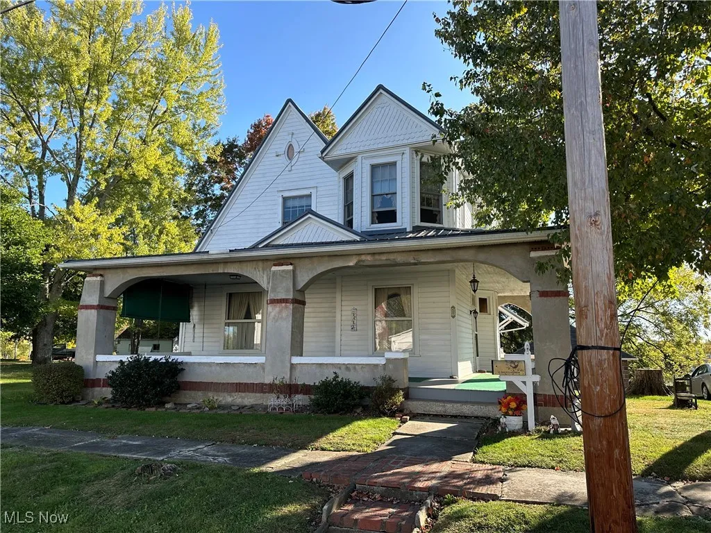 View of front of house with a front yard and covered porch