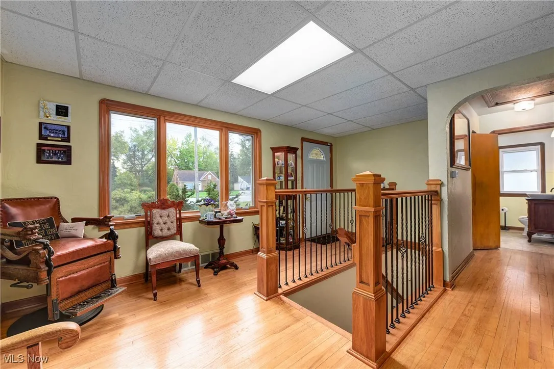 Waiting area with hardwood / wood-style flooring and a drop ceiling