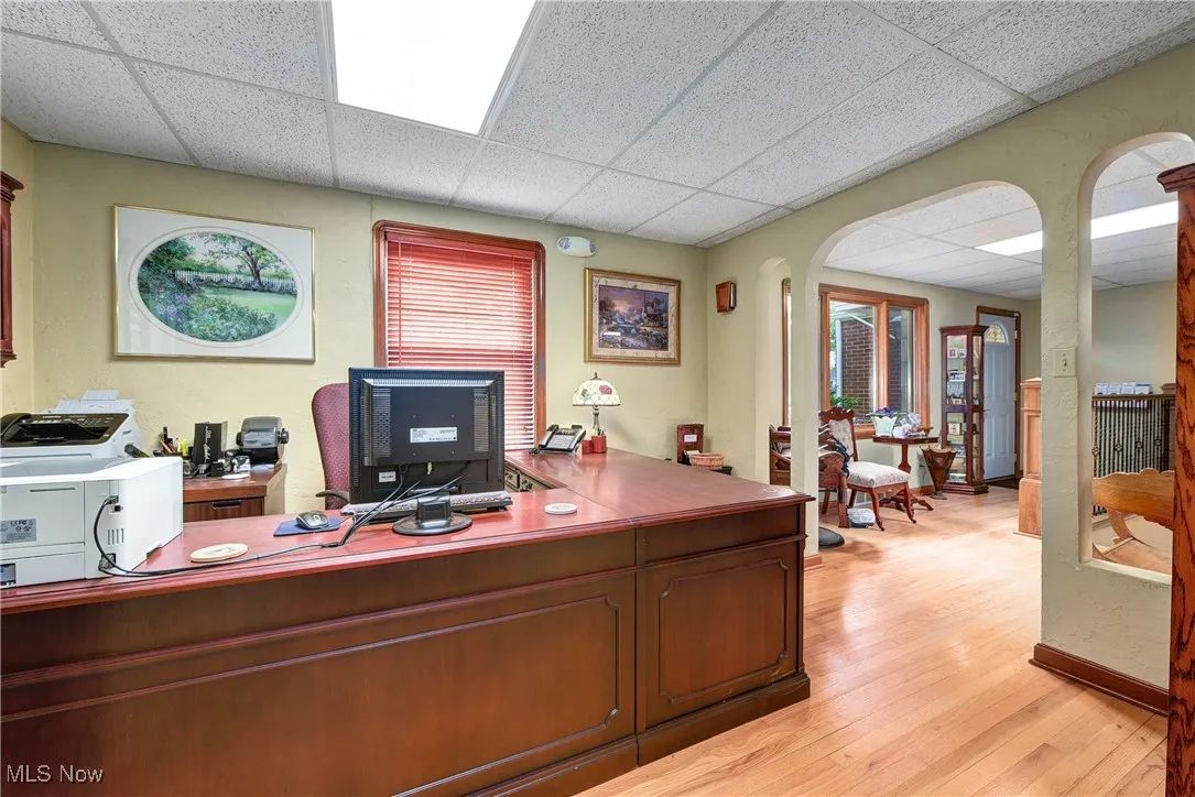 Office space with a paneled ceiling and light wood-type flooring