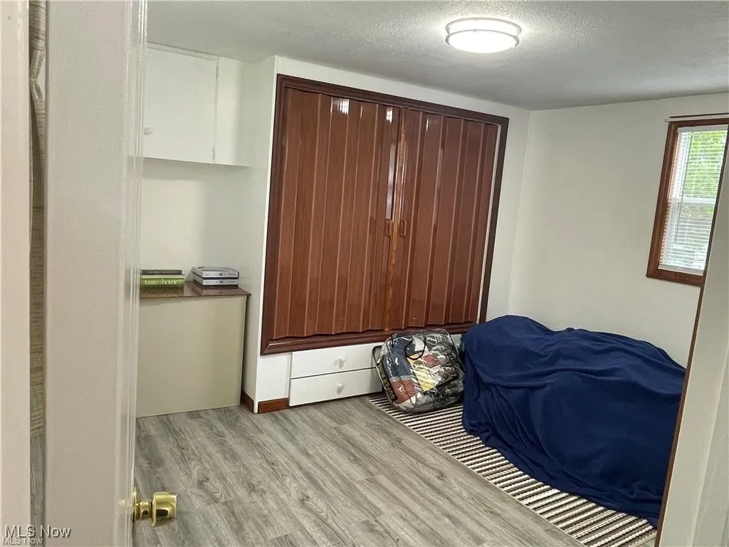 Bedroom with light hardwood / wood-style floors and a textured ceiling