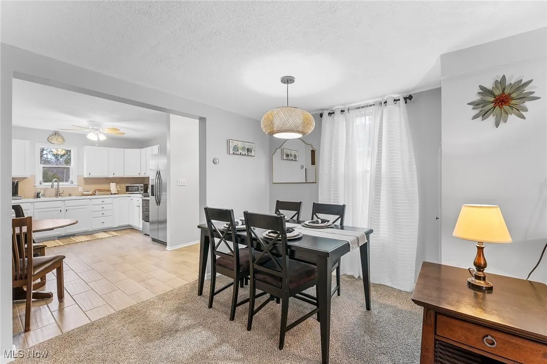 Dining area featuring ceiling fan, a textured ceiling, and sink