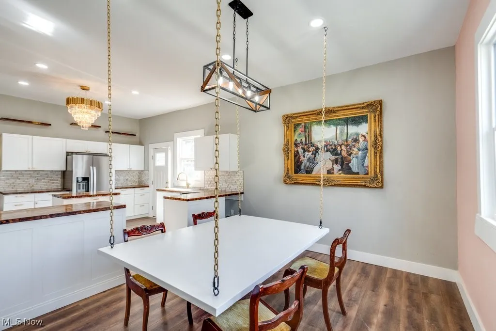 Dining space featuring sink and dark wood-type flooring