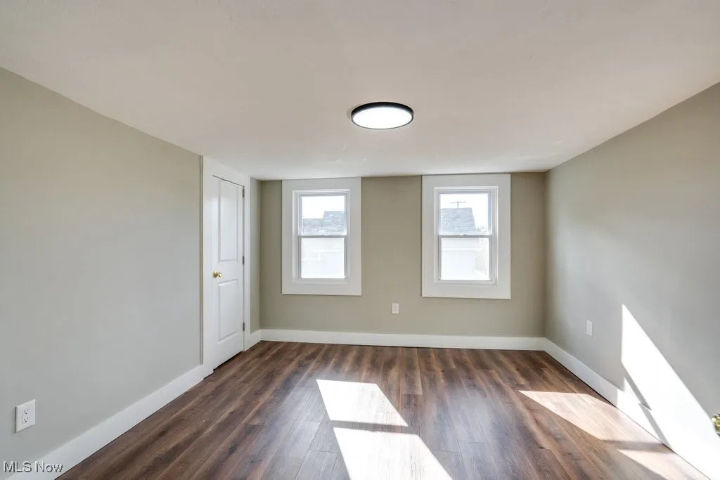 Empty room featuring dark wood-type flooring