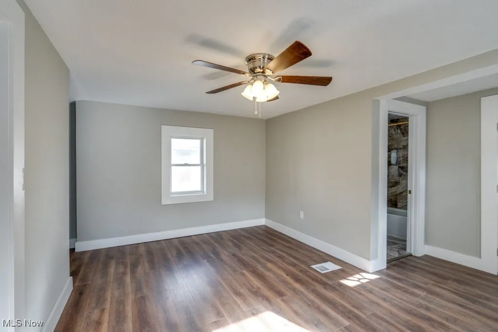 Spare room with ceiling fan and dark hardwood / wood-style flooring