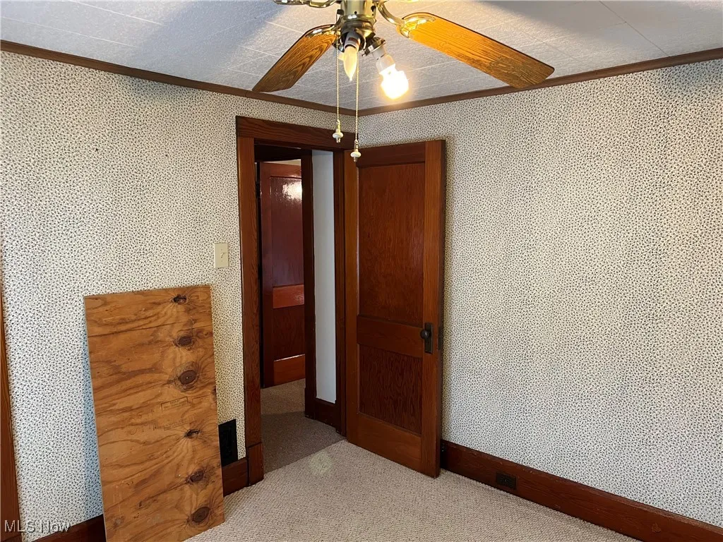 Unfurnished bedroom featuring ornamental molding, a textured ceiling, and ceiling fan