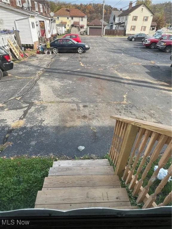 View of parking / parking lot featuring a garage