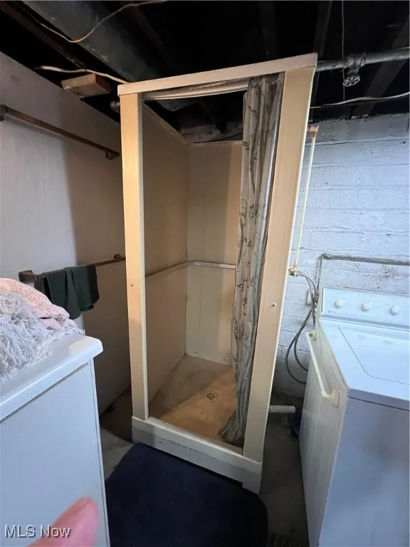Bathroom featuring washer / dryer, curtained shower, and vanity