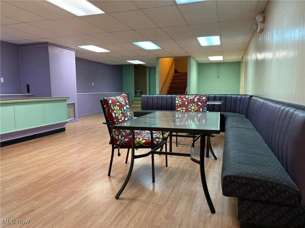 Dining area with a paneled ceiling and light wood-type flooring