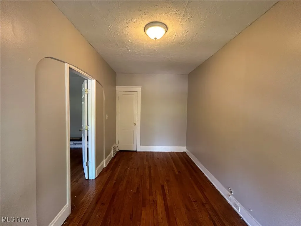 Hall with a textured ceiling and dark hardwood / wood-style​​‌​​​​‌​​‌‌​‌‌​​​‌‌​‌​‌​‌​​​‌​​ flooring
