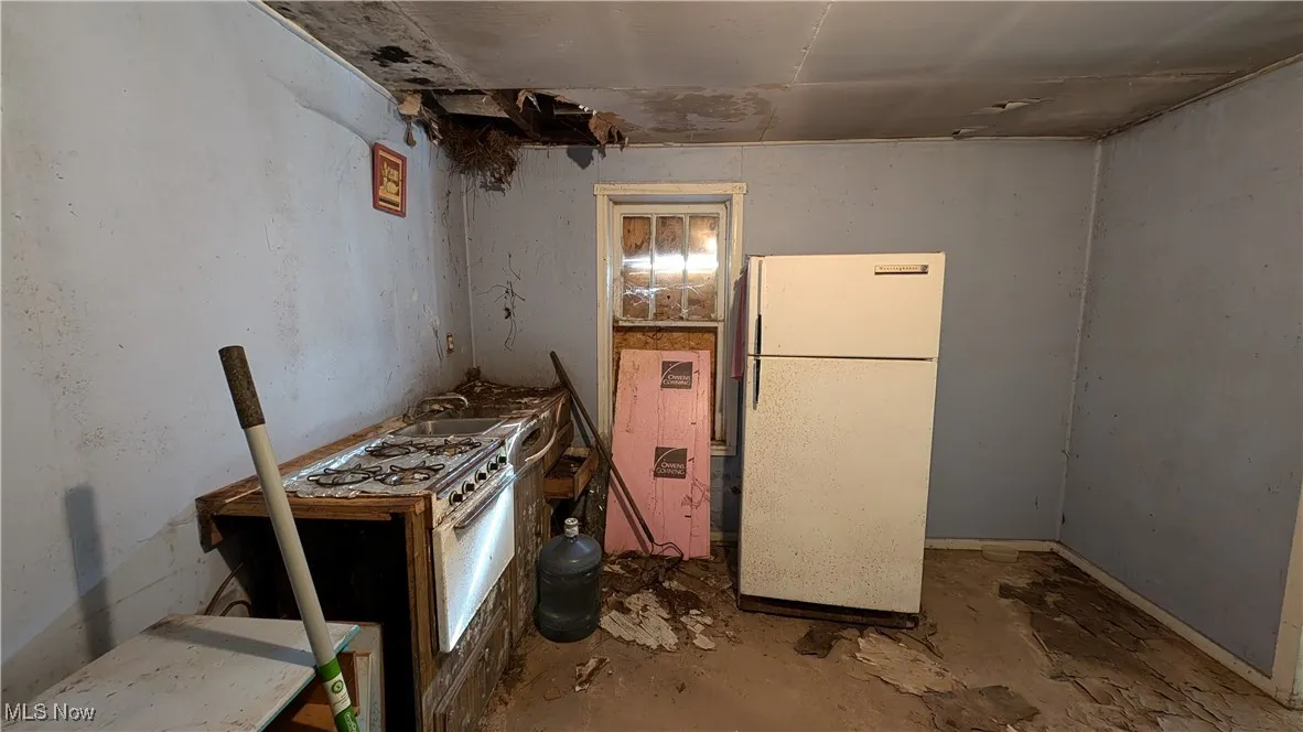 Kitchen featuring white appliances, concrete floors, and sink