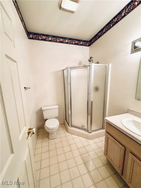 Full bath with a shower stall, toilet, and vanity