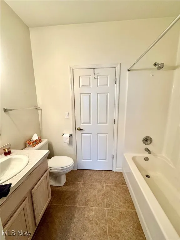 Full bathroom with tile patterned floors, vanity, toilet, and bathing tub / shower combination