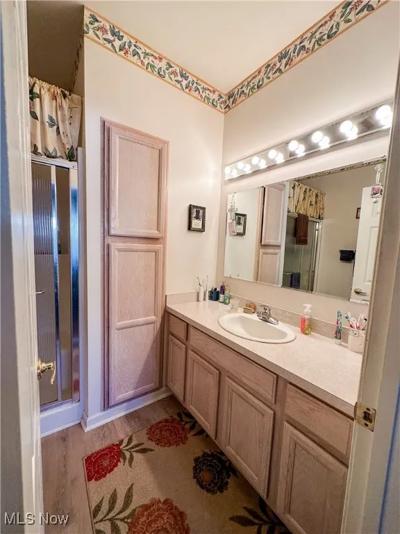 Bathroom featuring vanity, curtained shower, and hardwood / wood-style flooring