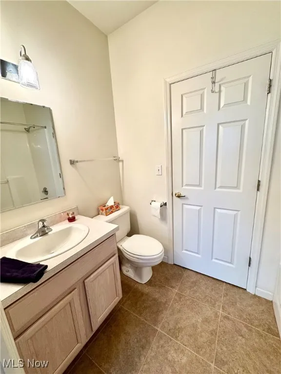 Bathroom featuring vanity, tile patterned floors, and toilet