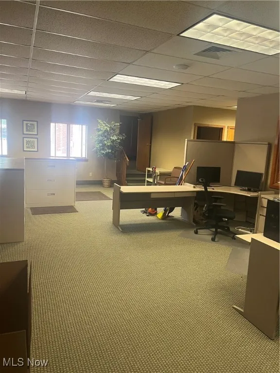 Carpeted office space with a paneled ceiling