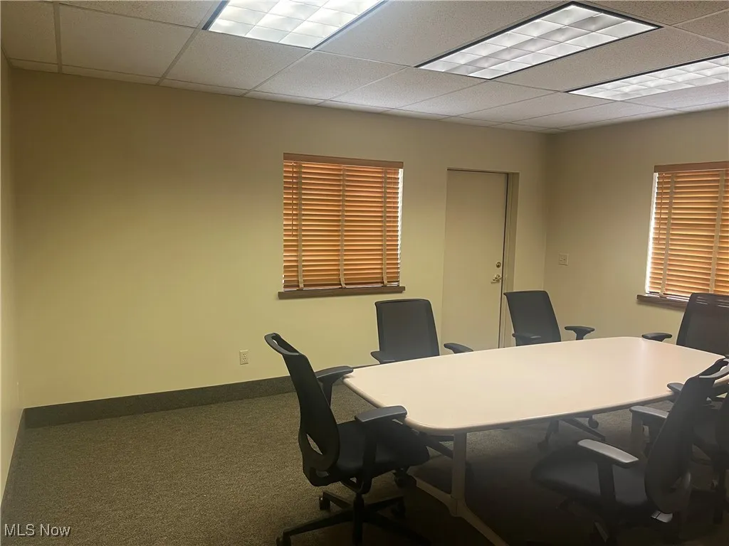 Carpeted office featuring a drop ceiling