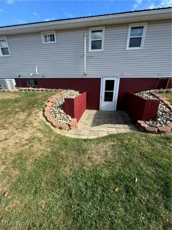 Back of house featuring a lawn and a patio area