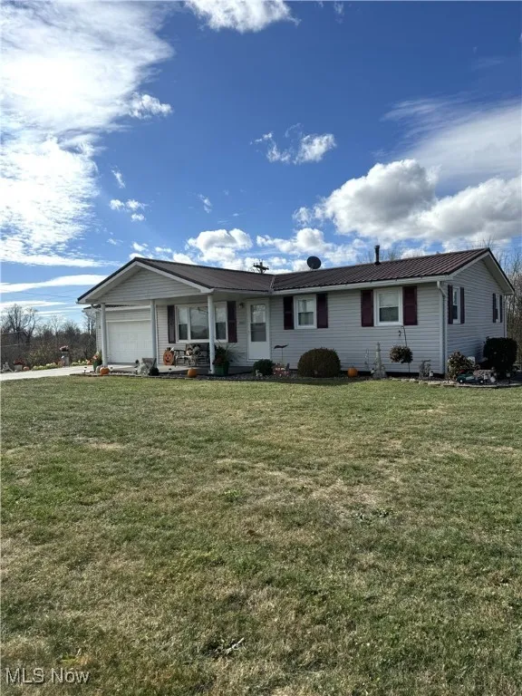 Single story home with a garage and a front yard