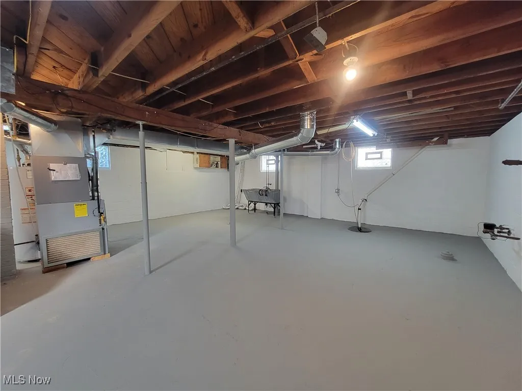 Basement featuring heating unit and sink