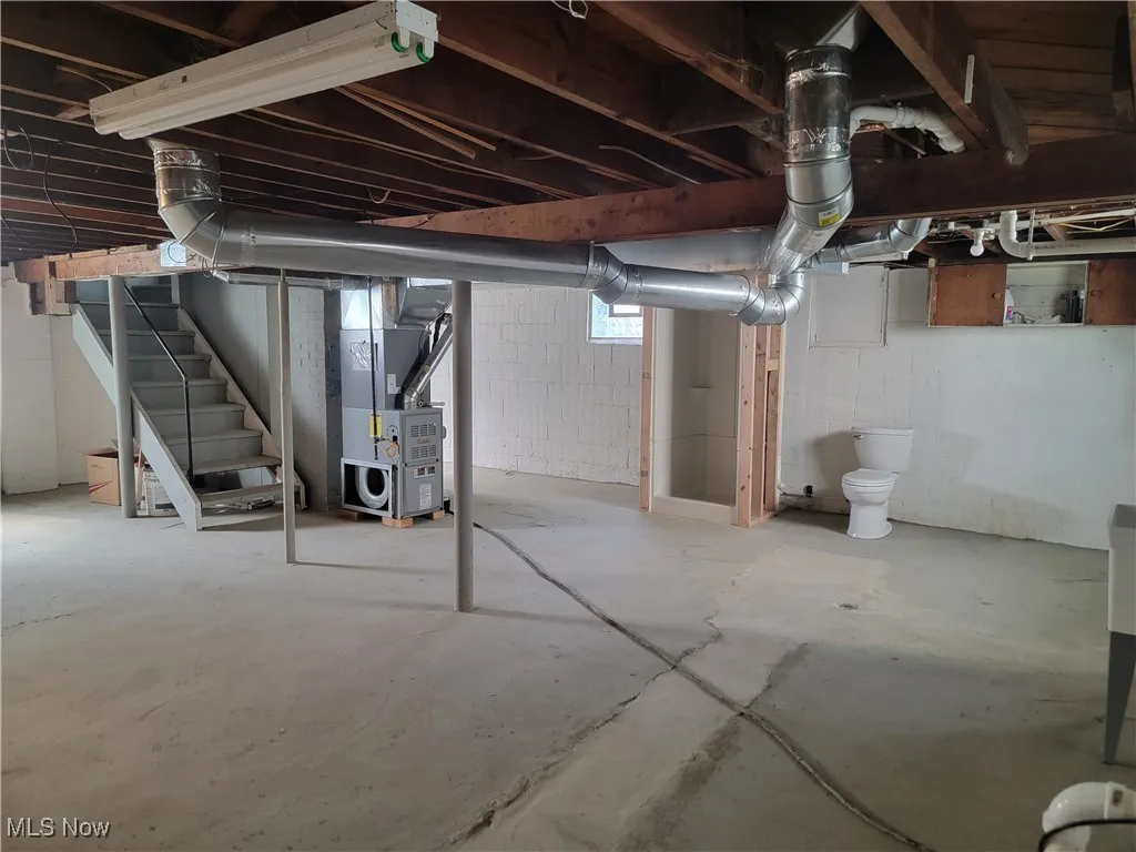 Below grade area with stairs and heating unit