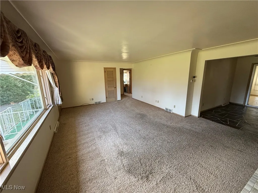 Unfurnished living room with dark carpet