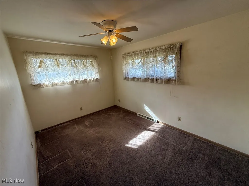 Carpeted spare room with ceiling fan