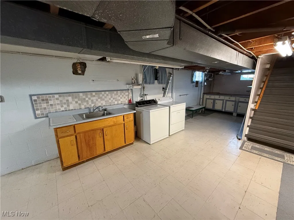 Kitchen with washing machine and clothes dryer and sink