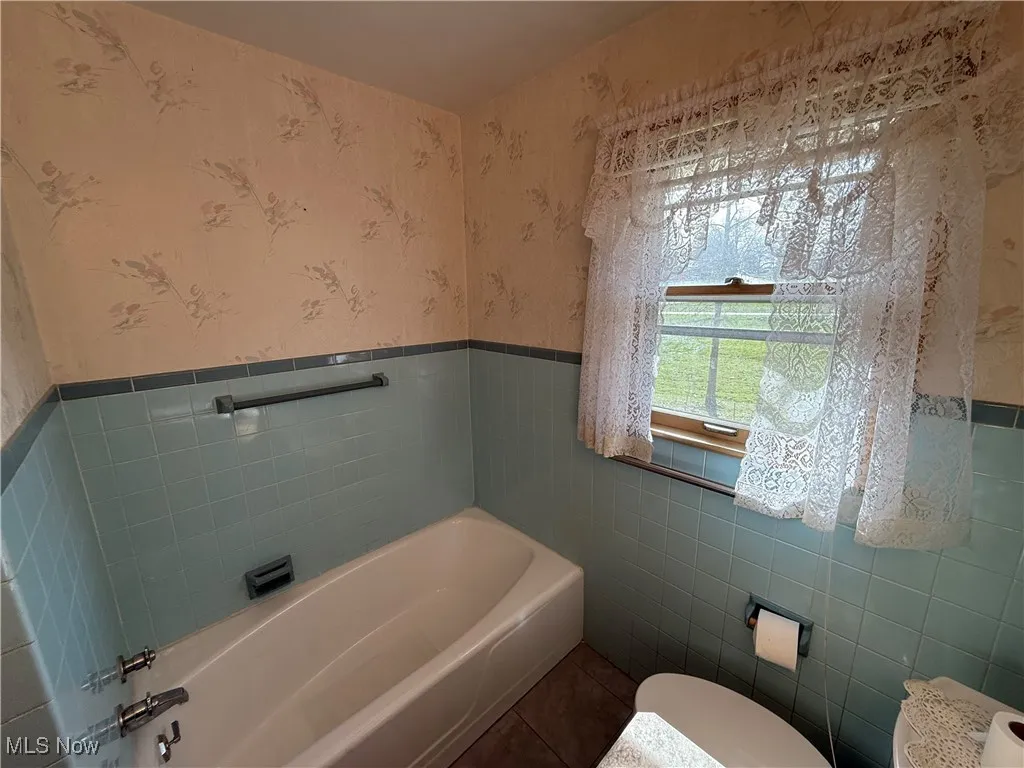 Bathroom with a bathing tub and tile walls