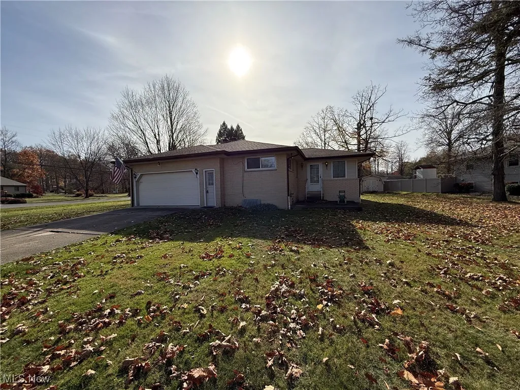 View of side of home with a lawn and a garage