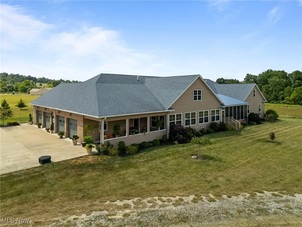 Back of property featuring a lawn, a sunroom, and a garage