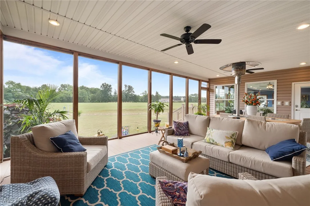 Sunroom featuring ceiling fan, plenty of natural light, and wood ceiling