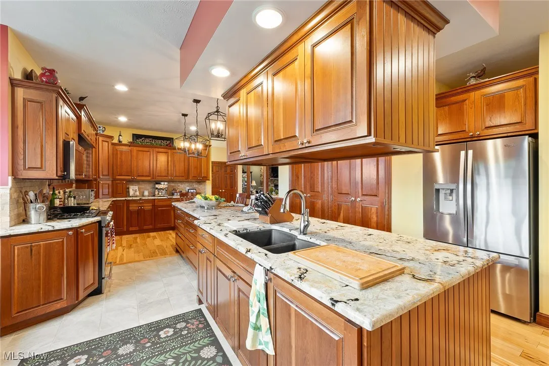 Kitchen featuring appliances with stainless steel finishes, tasteful backsplash, hanging light fixtures, and sink