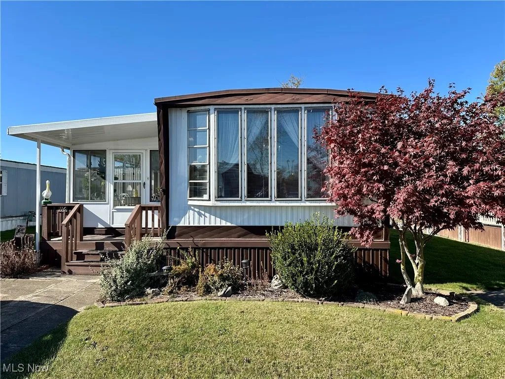 Back of house featuring a lawn and a sunroom