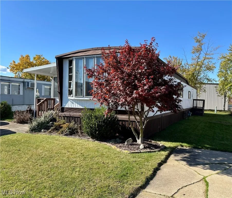 View of property exterior featuring a yard and a wooden deck