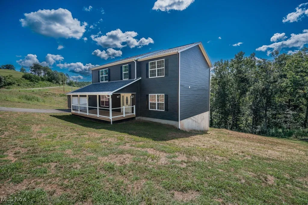 Back of property with a yard and a deck