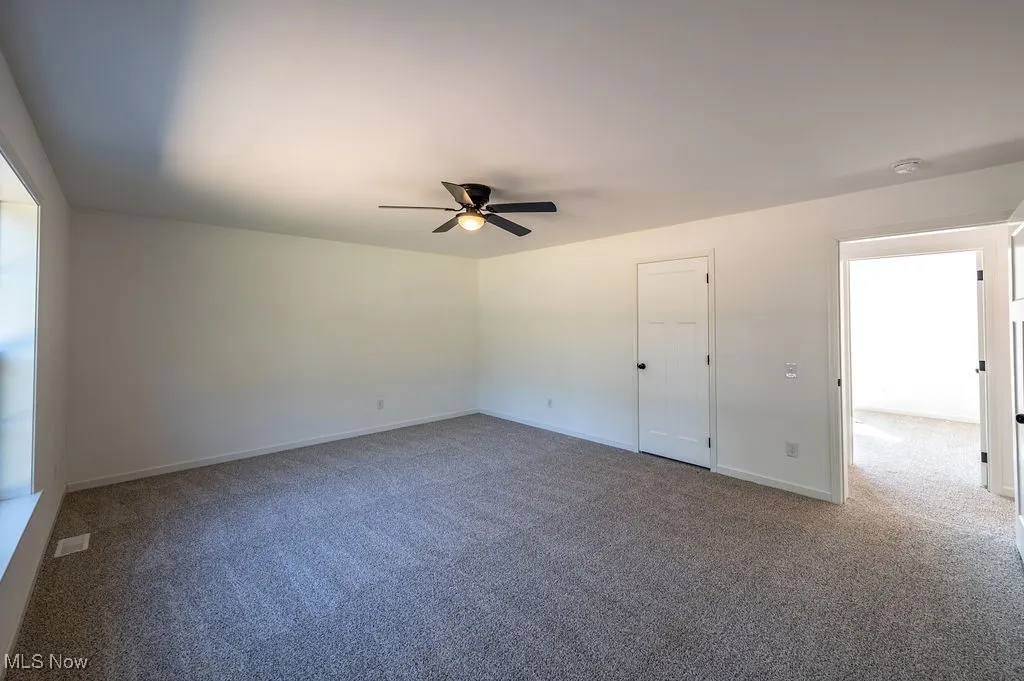 Unfurnished bedroom featuring carpet flooring and ceiling fan