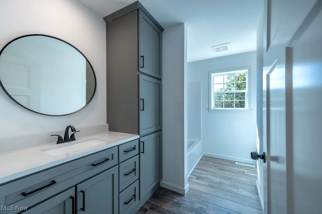 Bathroom featuring vanity, light wood-style floors, and tub / shower combination