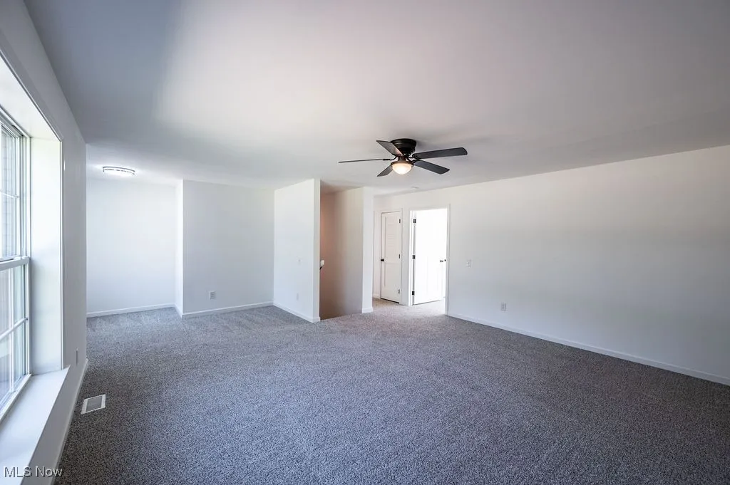 Spare room with carpet and ceiling fan