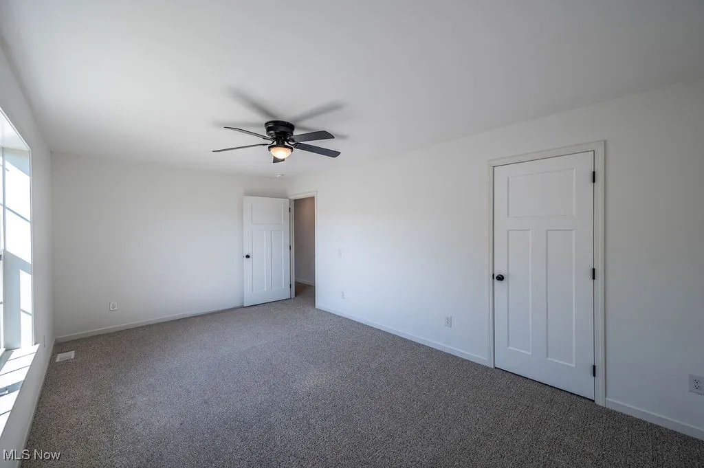 Unfurnished bedroom with carpet and ceiling fan
