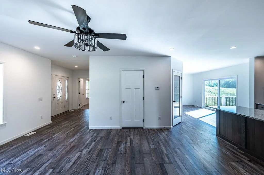 Unfurnished living room featuring recessed lighting, dark wood-style flooring, and a ceiling fan