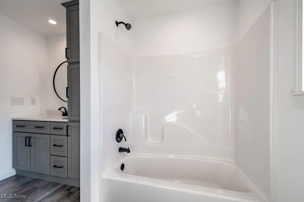 Full bathroom featuring shower / bathtub combination, dark wood finished floors, vanity, and recessed lighting