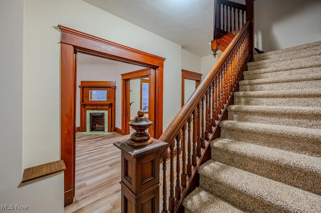 Stairs with wood-type flooring and a textured ceiling