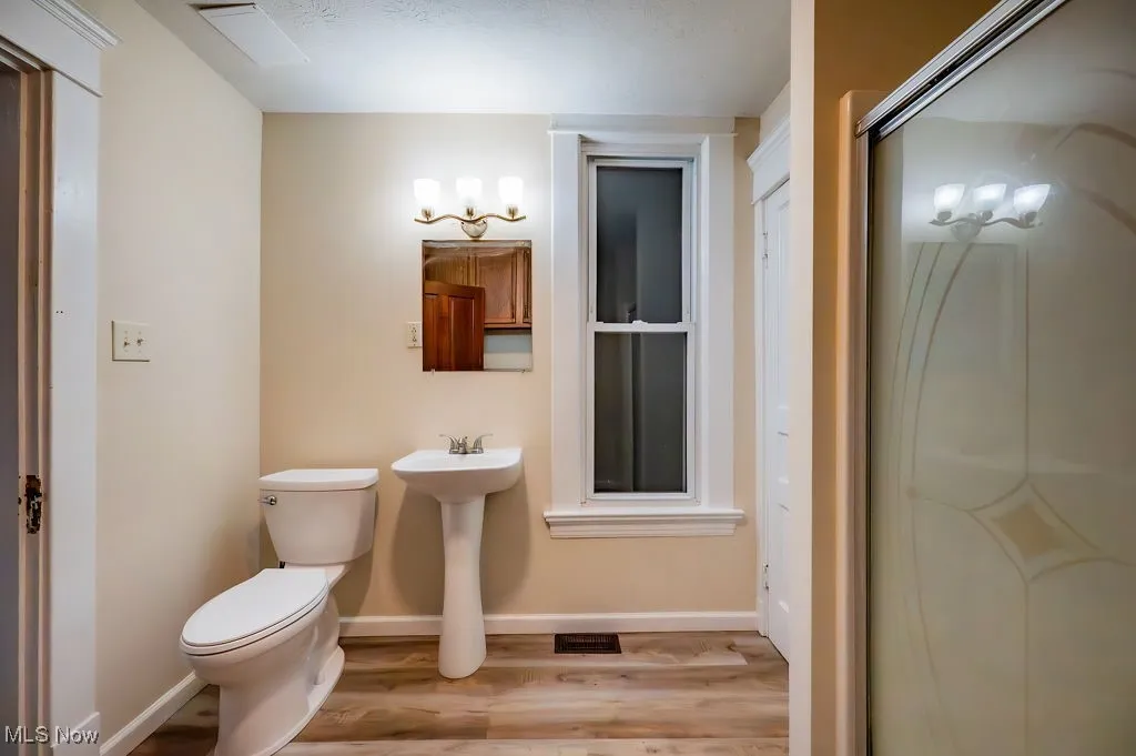 Bathroom featuring hardwood / wood-style flooring, toilet, and sink