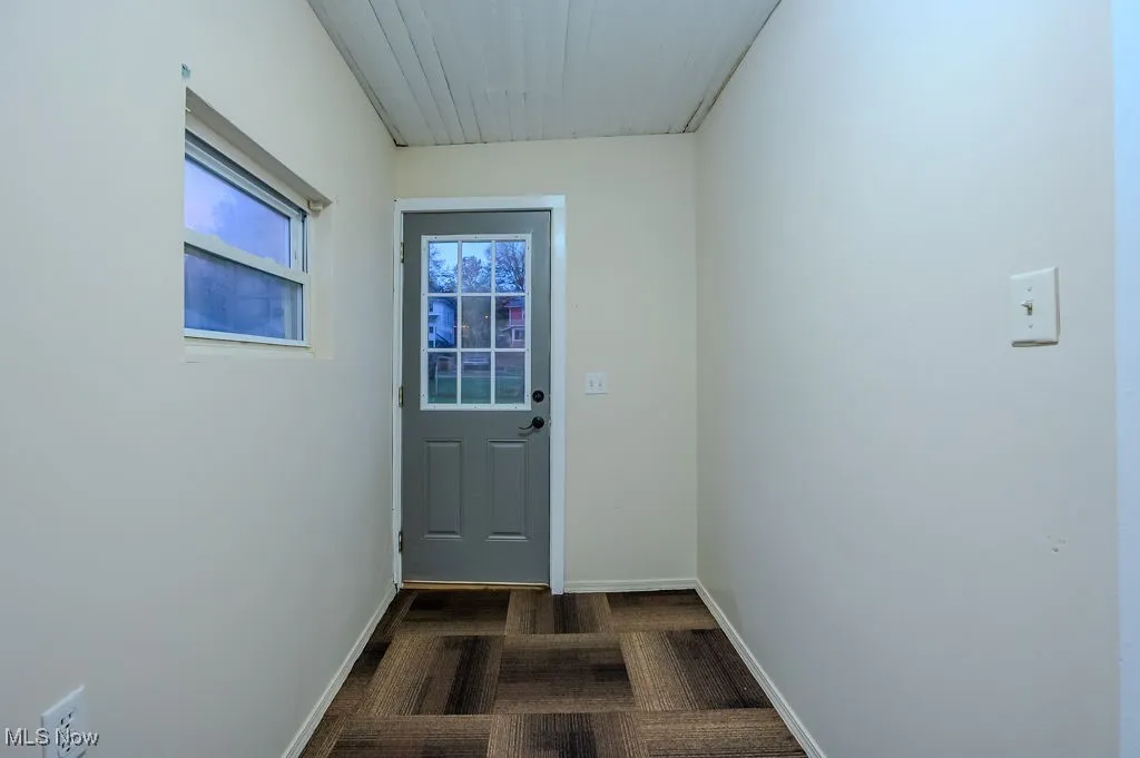 Doorway to outside with dark wood-type flooring
