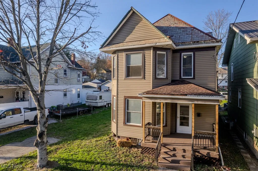 Front of property featuring covered porch and a front lawn