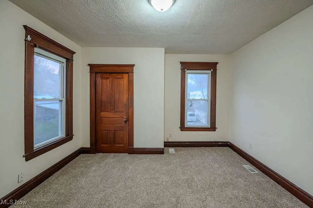 Unfurnished bedroom featuring carpet and a textured ceiling