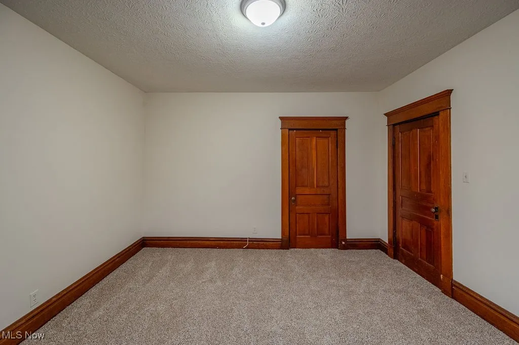 Empty room featuring carpet floors and a textured ceiling