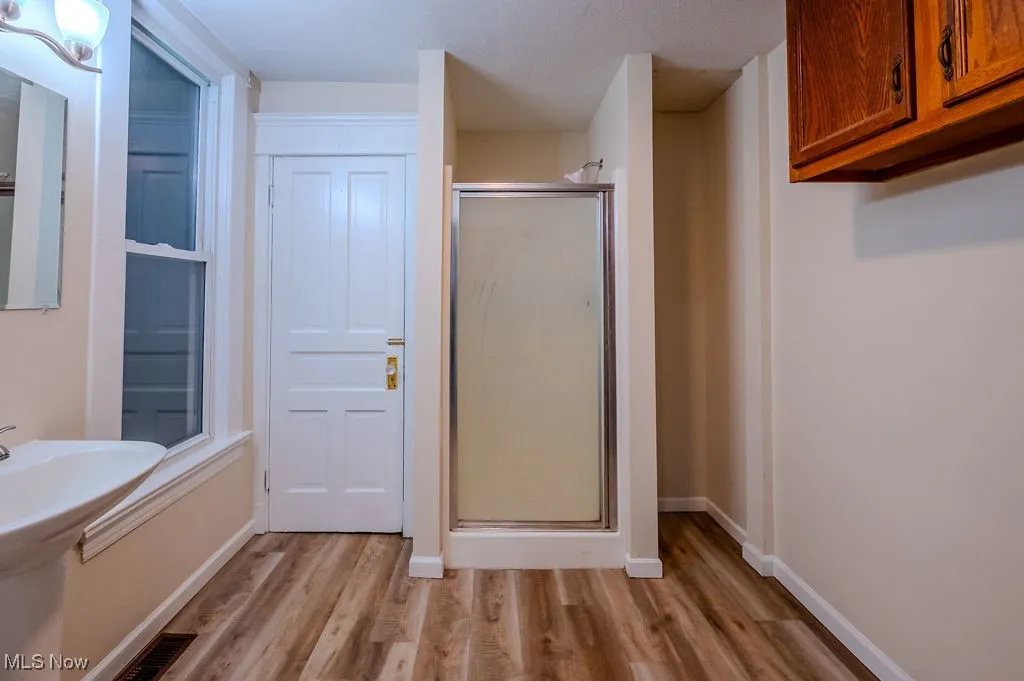 Bathroom featuring walk in shower and hardwood / wood-style flooring