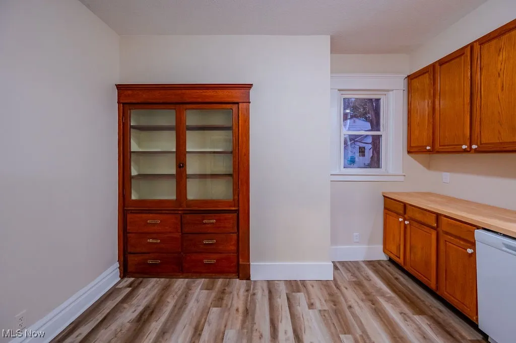Kitchen featuring light wood-type flooring and white dishwasher